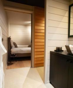 ein Bad mit einer Tür, die zu einem Schlafzimmer führt in der Unterkunft Suites de la vallée 6 in Érezée