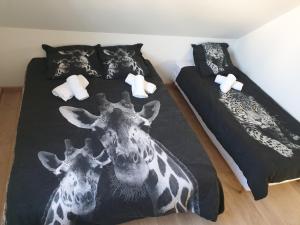 1 dormitorio con 2 jirafas en la cama en Le Safari - Dormir Comme A La Maison, en Guérande