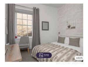 um quarto com uma cama, uma cadeira e uma janela em King’s stable 2 rooms em Edinburgo