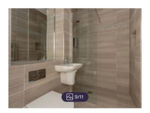 uma casa de banho com um lavatório branco e um espelho. em King’s stable 2 rooms em Edinburgo