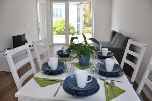 a white dining room table with blue dishes on it at Apartments Trnovo in Ljubljana