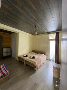 a bedroom with a large bed with a wooden ceiling at Mountain Dream House in Gudauri