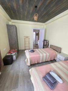 a bedroom with two beds and a wooden ceiling at Mountain Dream House in Gudauri