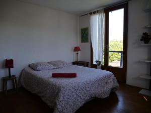 a bedroom with a bed with a red pillow on it at Izpi Urdin Holistic surfhouse in Saint-Jean-de-Luz
