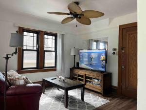 a living room with a television and a ceiling fan at Nice 1 BR Apt, WIFI & Office, Near State Fair in West Allis