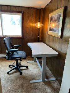 a office with a desk and a chair and a lamp at Nice 1 BR Apt, WIFI & Office, Near State Fair in West Allis