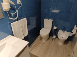 a blue bathroom with a toilet and a sink at Garden House Fundão - Suíte 103 com varanda in Fundão