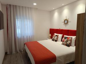 a bedroom with a large bed with a red headboard at Garden House Fundão - Suíte 103 com varanda in Fundão