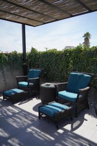 拉巴斯的住宿－Villa Esterito，庭院里设有三把椅子和一张桌子