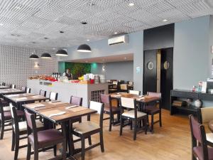 a restaurant with wooden tables and chairs and a kitchen at Flat IMPECAVEL proximo aos Shoppings JK e Vila Olimpia in Sao Paulo
