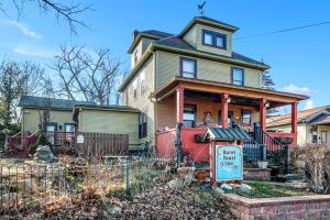 een oud huis met een bord ervoor bij Burnt Toast Inn in Ann Arbor