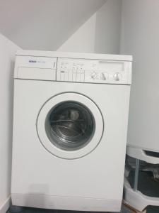 una lavadora blanca en una habitación en Le Safari - Dormir Comme A La Maison, en Guérande