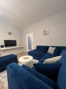 a living room with a blue couch and a tv at Central Gem Tirana in Tirana