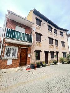 un edificio de ladrillo con ventanas y puertas en una calle en Casa Dalla, en Miraflores de la Sierra