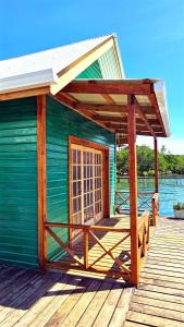 un bâtiment verdoyant avec une terrasse couverte en bois dans l'établissement The Sea Monkey, à Bocas del Toro