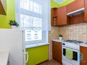 a kitchen with a white stove and a window at Soft Room in Gdańsk