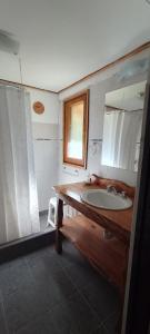 uma casa de banho com um lavatório e um espelho em Chacra Kaiken Lodge em Perito Moreno
