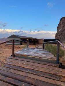 a wooden boardwalk leading to a building in the desert at Zawaideh desert Camp in Wadi Rum