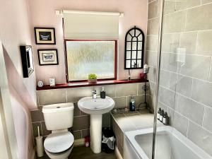 a bathroom with a toilet and a sink and a tub at 50 Etherley Lane in Bishop Auckland +6 photos