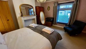 a bedroom with a bed and a chair and a mirror at 50 Etherley Lane in Bishop Auckland