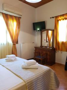 a bedroom with a bed and a desk and a mirror at Stone Edge Homestead in Agios Leon +31 photos