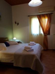 a bedroom with a bed with towels on it at Stone Edge Homestead in Agios Leon