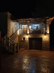 a stone building with stairs and a balcony at night at Stone Edge Homestead in Agios Leon