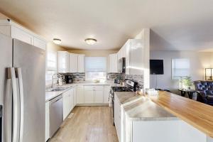 a kitchen with white cabinets and a wooden floor at Garden Cottage in Rapid City