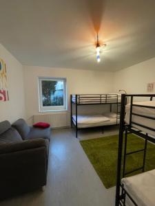 奧斯納布呂克的住宿－JonnysHostel，客厅配有两张双层床和一张沙发