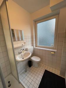 ein Bad mit einem WC, einem Waschbecken und einem Fenster in der Unterkunft JonnysHostel in Osnabrück