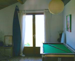 Habitación con mesa de billar y ventana en Izpi Urdin Holistic surfhouse, en San Juan de Luz