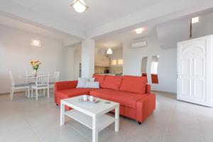 salon z czerwoną kanapą i stołem w obiekcie Corfu Sea View Villa - Eros w mieście Barbati