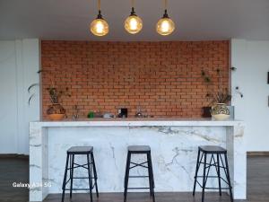 a kitchen with two bar stools and a brick wall at Ideal para compartir momentos especiales 