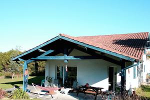 a house with a roof and a table and chairs at Izpi Urdin Holistic surfhouse in Saint-Jean-de-Luz