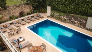 an overhead view of a swimming pool with chairs and a table at Natu Hotel Boutique & Spa in Atibaia