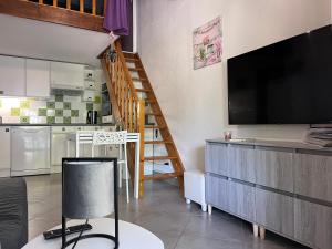 a living room with a large television and a staircase at La Villa Michaelenanne in Port Leucate