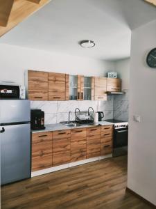 維斯瓦的住宿－Domki U Uli，厨房配有木制橱柜和不锈钢冰箱。