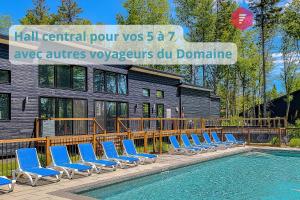 eine Reihe blauer Stühle neben einem Pool in der Unterkunft Casa Ibéricos in Portneuf / SPA Pool Sauna Trails in Pont-Rouge
