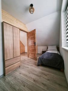 sypialnia z łóżkiem i drewnianymi drzwiami w obiekcie Domki U Uli w Wiśle