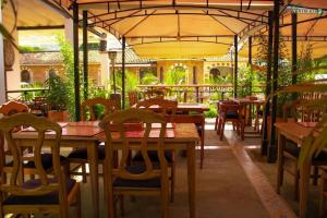 un restaurant avec des tables et des chaises en bois ainsi qu'un parasol dans l'établissement VILLA NATURAL, à Fómeque
