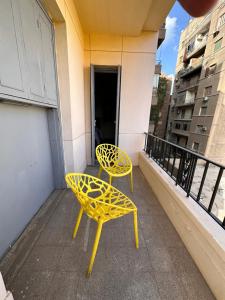 a pair of yellow chairs sitting on a balcony at Economy room in Downtown in Cairo