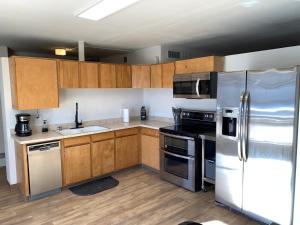 a kitchen with wooden cabinets and stainless steel appliances at Emerald Lake House *Boat Parking with a View in Page