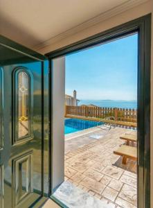 a sliding glass door leading to a patio with a pool at Corfu Sea View Villa - Sequoia in Barbati