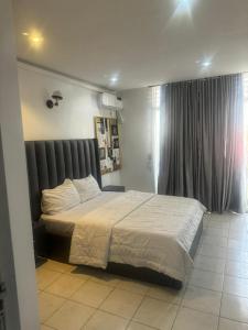 ein Schlafzimmer mit einem großen Bett und einem Fenster in der Unterkunft Merry Villa in Lagos