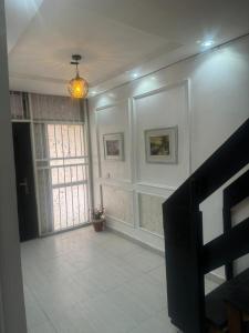 ein Wohnzimmer mit einem großen Fenster und weißen Wänden in der Unterkunft Merry Villa in Lagos