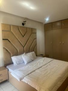 a bedroom with a large bed with a large headboard at Merry Villa in Lagos