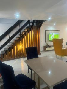 a living room with a table and chairs and a tv at Merry Villa in Lagos
