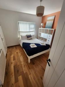 a bedroom with a white bed and a wooden floor at Risca Inspire in Risca