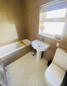 a bathroom with a sink and a toilet and a window at Risca Inspire in Risca