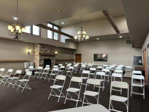 a room with rows of white chairs and a fireplace at Clock Tower Inn in Berne